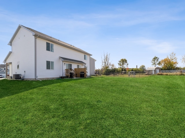 back of property featuring central air condition unit and a yard