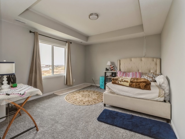 bedroom with carpet flooring and a raised ceiling