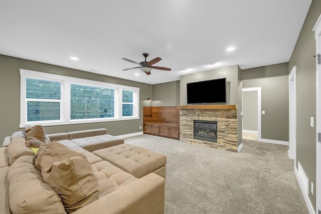 carpeted living room with ceiling fan and a fireplace