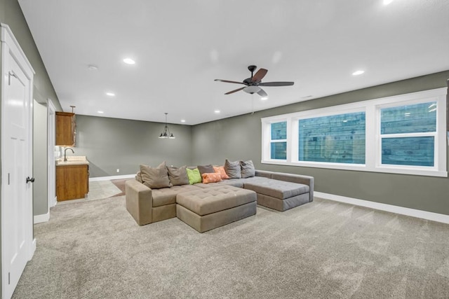 carpeted living room with sink and ceiling fan