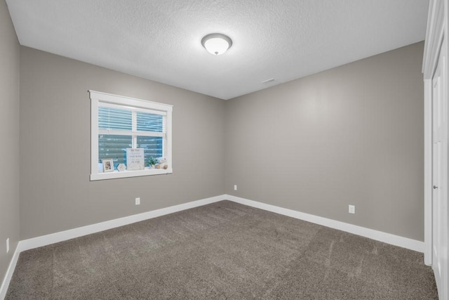 carpeted spare room featuring a textured ceiling