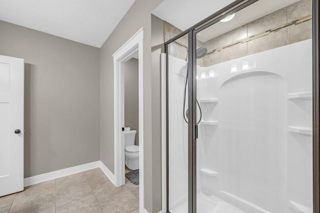 bathroom featuring an enclosed shower, tile patterned floors, and toilet