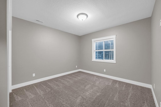 spare room featuring carpet and a textured ceiling