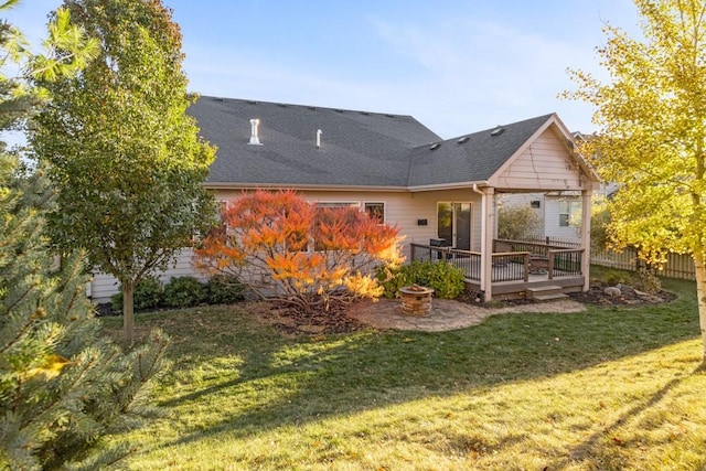 back of house with a deck and a lawn