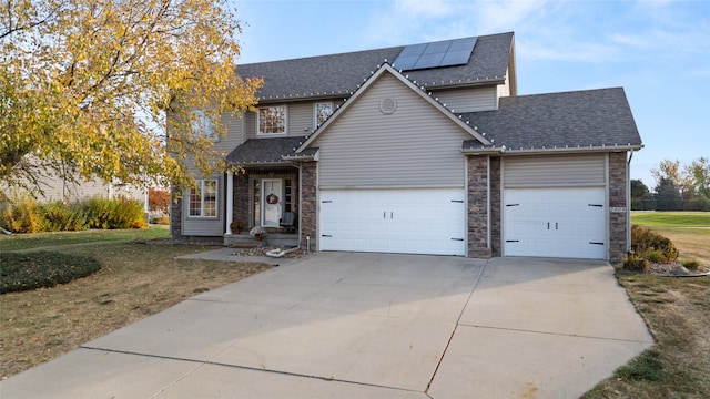 view of front facade with a front yard, solar panels, and a garage