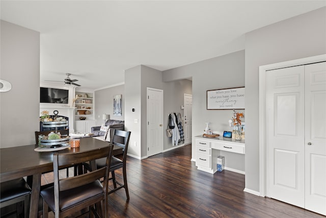 dining space with dark wood-type flooring, ceiling fan, crown molding, and built in desk