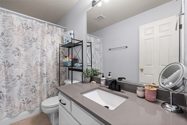 full bathroom with vanity, shower / bath combo, a textured ceiling, and toilet