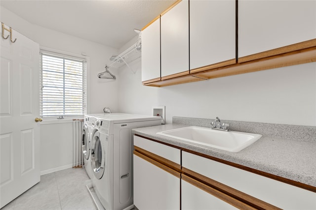 clothes washing area with sink, independent washer and dryer, light tile patterned floors, and cabinets