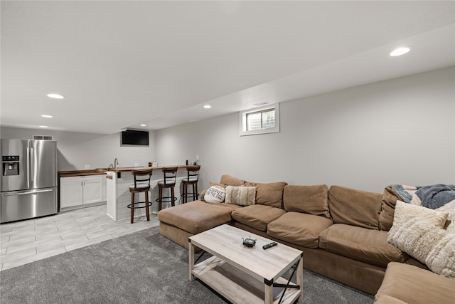 living room featuring wet bar and light colored carpet