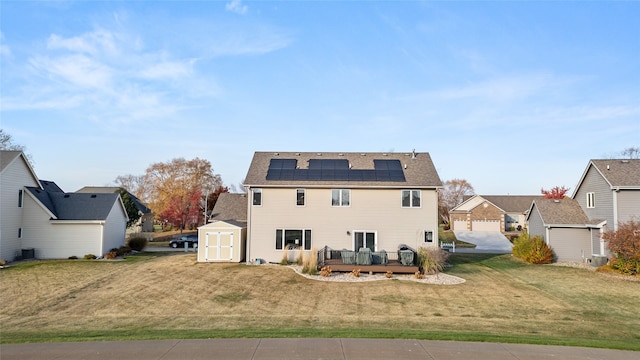 rear view of property with cooling unit, a wooden deck, a storage shed, a lawn, and solar panels