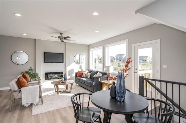 living room featuring lofted ceiling, wood-type flooring, and ceiling fan