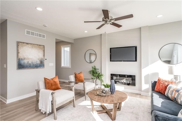 living room with light hardwood / wood-style flooring and ceiling fan