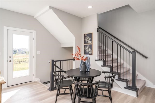 dining room featuring lofted ceiling and light wood-type flooring