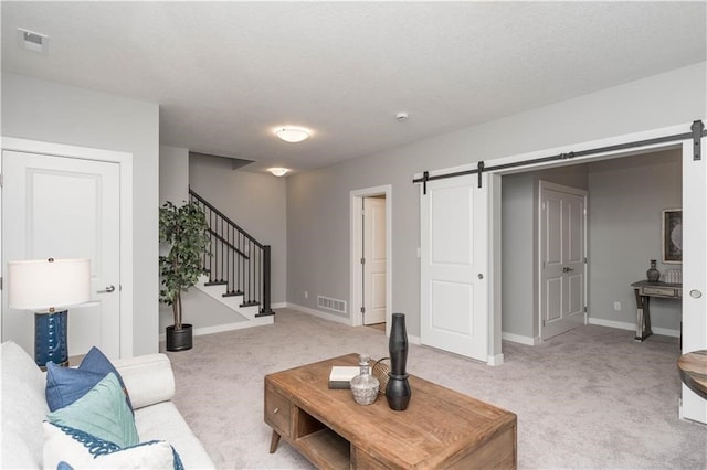 carpeted living room featuring a barn door