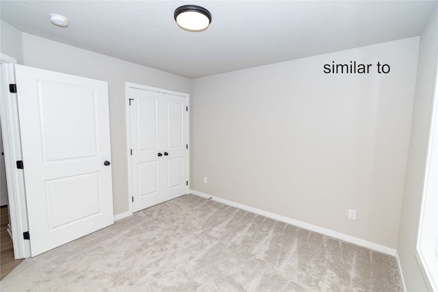 unfurnished bedroom featuring a closet and light carpet