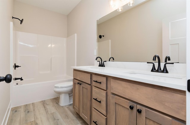 bathroom featuring a sink, shower / bath combination, toilet, and wood finished floors