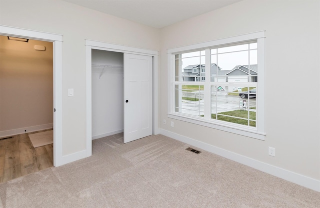 unfurnished bedroom with a closet, baseboards, and carpet flooring