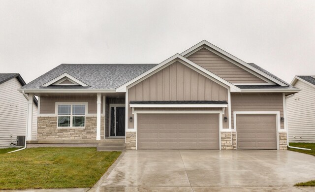 craftsman-style home with cooling unit, a garage, and a front yard