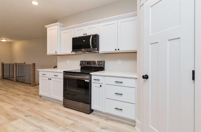 kitchen with light wood-style flooring, white cabinetry, recessed lighting, appliances with stainless steel finishes, and light countertops