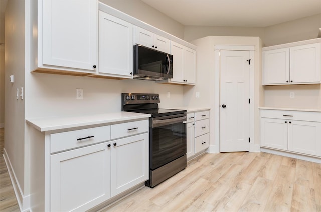 kitchen featuring baseboards, light countertops, electric stove, light wood-style floors, and white cabinetry