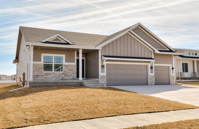 view of front of home with stone siding, roof with shingles, board and batten siding, concrete driveway, and an attached garage