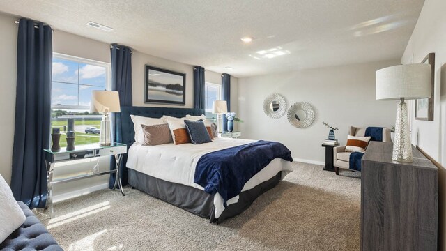 carpeted bedroom with visible vents, baseboards, and a textured ceiling