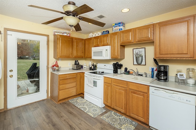 kitchen with white appliances, dark wood-type flooring, a textured ceiling, and sink