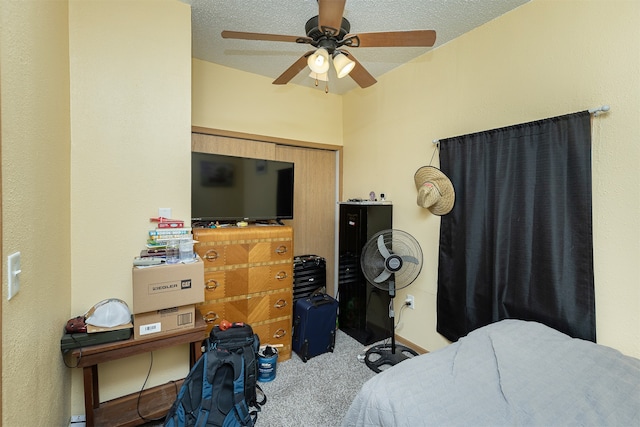 carpeted bedroom featuring a closet, ceiling fan, and a textured ceiling