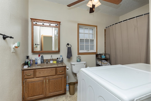 bathroom featuring washer / dryer, a textured ceiling, toilet, ceiling fan, and vanity