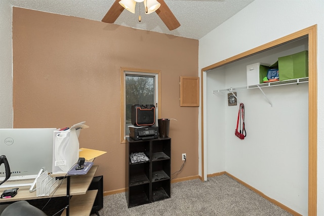 carpeted office featuring a textured ceiling and ceiling fan