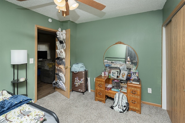 carpeted bedroom with a closet, a textured ceiling, and ceiling fan