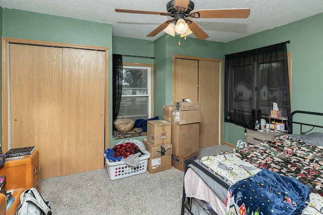 carpeted bedroom with ceiling fan and a textured ceiling