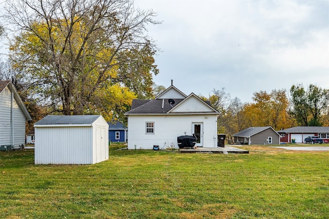 back of house featuring a shed and a lawn