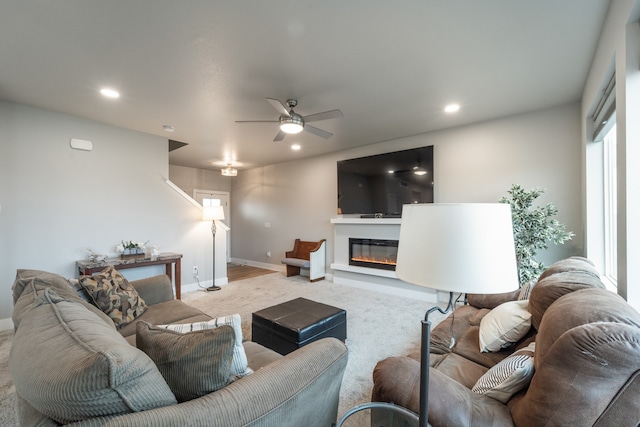 carpeted living room with a wealth of natural light and ceiling fan