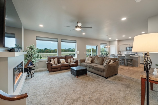 living room featuring light carpet and ceiling fan