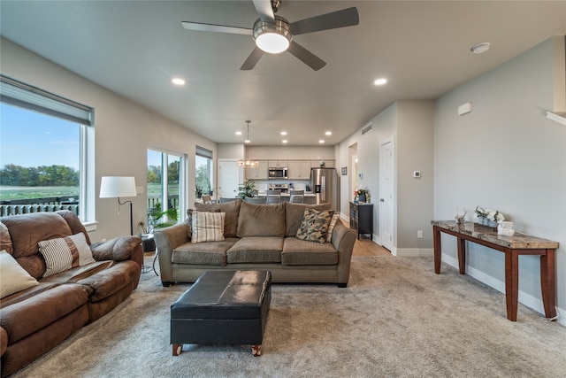 living room with light colored carpet and ceiling fan