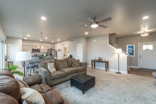 living room with light hardwood / wood-style floors and ceiling fan