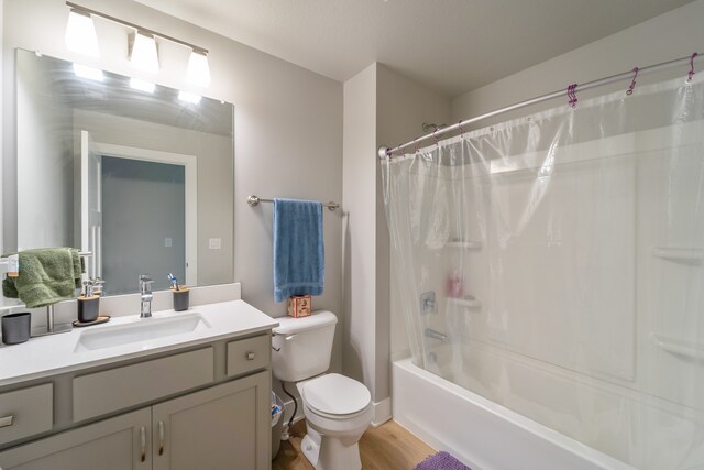 full bathroom featuring vanity, shower / tub combo, hardwood / wood-style flooring, and toilet