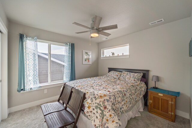 carpeted bedroom with ceiling fan and multiple windows