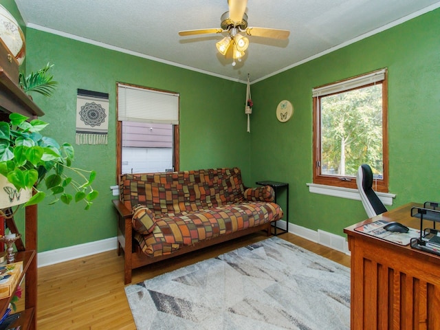 office area featuring ceiling fan, ornamental molding, and light hardwood / wood-style flooring