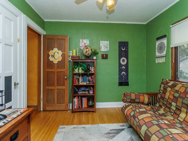 bedroom with ornamental molding, light hardwood / wood-style flooring, a textured ceiling, and ceiling fan