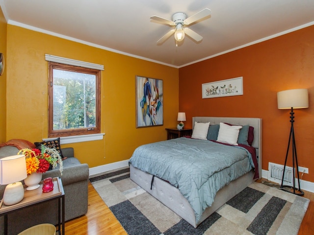 bedroom featuring ceiling fan, hardwood / wood-style flooring, and ornamental molding