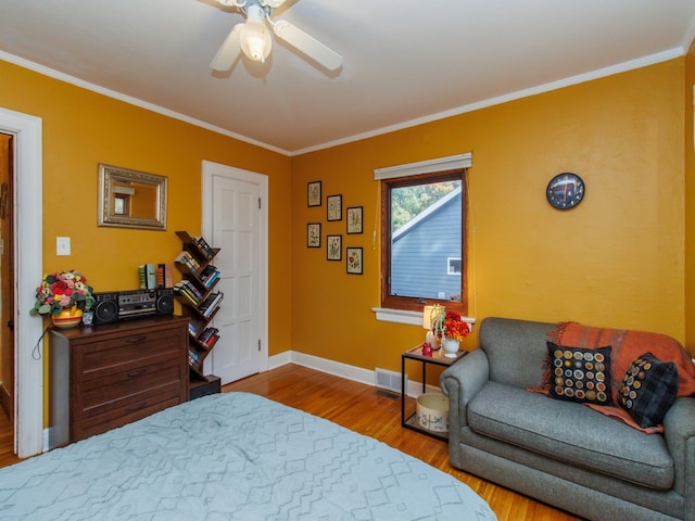 bedroom featuring hardwood / wood-style floors, crown molding, and ceiling fan