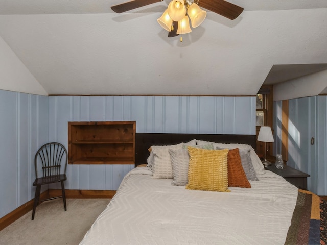 carpeted bedroom with ceiling fan, a textured ceiling, and vaulted ceiling