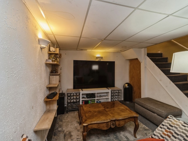 carpeted living room featuring a drop ceiling