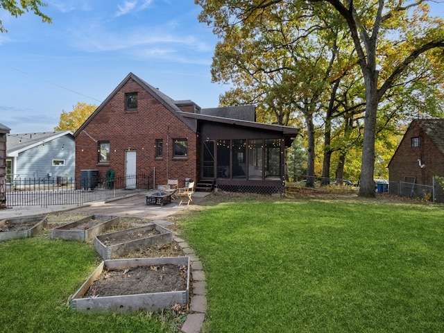 back of house with a patio area, a lawn, and a sunroom