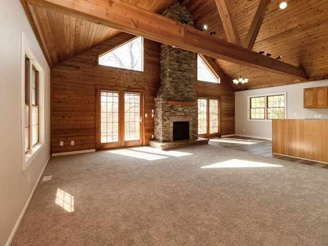 unfurnished living room with beam ceiling, an inviting chandelier, carpet, and high vaulted ceiling