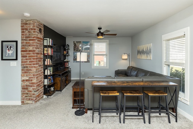 living room with light carpet, ceiling fan, and decorative columns