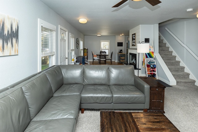 carpeted living room with a textured ceiling, a healthy amount of sunlight, and ceiling fan