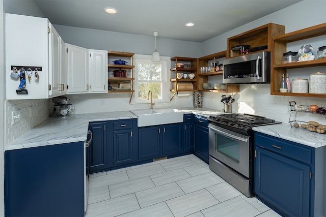 kitchen featuring appliances with stainless steel finishes, sink, light stone counters, white cabinetry, and blue cabinetry